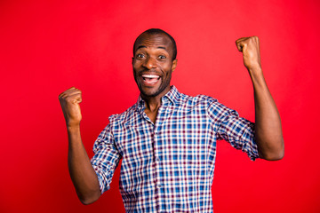 Portrait of nice handsome cheerful cheery glad optimistic guy wearing checked shirt showing winning...