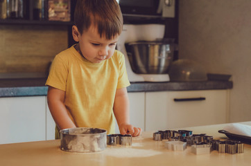 Fototapeta na wymiar Portrait of child Boy Start Cooking at Kitchen. Young Cute Children Wearing Casual Clothes. Start Making Cake Holding Rolling Pins in Hands. Food Preparation Concept