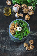 Cooking parsley pesto with walnuts. Ingredients for pesto in a blender cup.