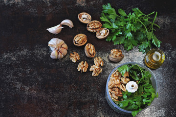 Fototapeta na wymiar Cooking parsley pesto with walnuts. Ingredients for pesto in a blender cup.