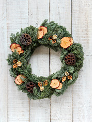 Christmas wreath made from natural dried materials on a white wooden background 