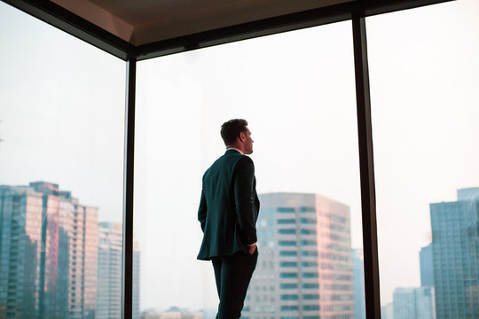 Businessman looking out at city skyline 