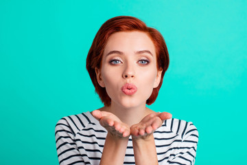 Naklejka premium Close-up portrait of nice attractive lovely lovable red-haired lady in striped pullover sending air kiss isolated over bright vivid shine green turquoise background