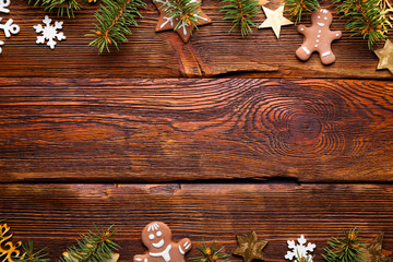 Christmas spruce tree, gingerbread cookies and decorations on wooden table