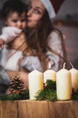 mother with santa hat holding her baby at christmas time