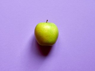 Above view of a Green apple isolated in a violet background in studio