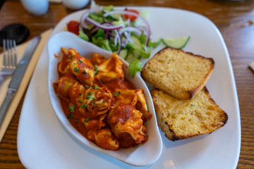 Italian dumplings in a tomato sauce with garlic bread. Food in the restaurant with a bokeh effect.