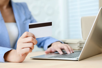 Hand holding credit card typing on the keyboard of laptop for online shopping ecommerce concept