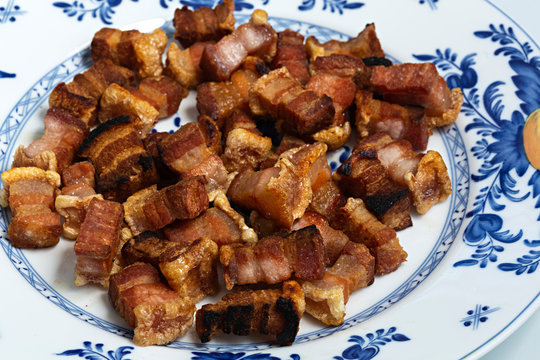 Trozos de tocino de cerdo fritos.