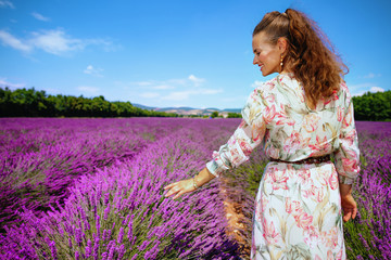woman in lavender field in Provence, France touching lavender