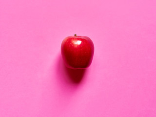 Above view of a red apple isolated in a fucsia background in studio top view