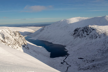 overlooking loch avon within the cairngorms national park, scotland with snow cover on a bright sunny winters day.