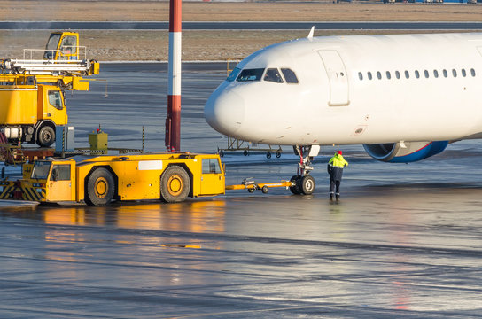 The Pushback Tractor Is Towing The Aircraft To A Parking Lot, Aviation Marshall.