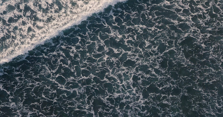 Aerial view beautiful of sea waves from drone. Stock image of blue color of ocean water, sea surface. Top view on turquoise waves, clear water surface texture.  Top view, amazing nature background