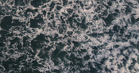 Aerial view beautiful of sea waves from drone. Stock image of blue color of ocean water, sea surface. Top view on turquoise waves, clear water surface texture.  Top view, amazing nature background