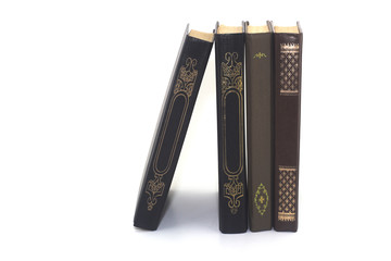 four old books standing on a white background close-up