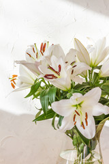 Flower bouquet, white lilies in a vase. White background.