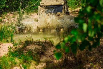 Jeep outdoors adventures. Expedition offroader. Safari suv. Off-road vehicle goes on the mountain. 4x4 travel trekking. Mudding is off-roading through an area of wet mud or clay.