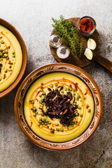 Authentic Greek Fava recipe, Middle Eastern yellow lentil soup with caramelized onions, paprika and capers. vegan healthy food in clay pots on the stone table