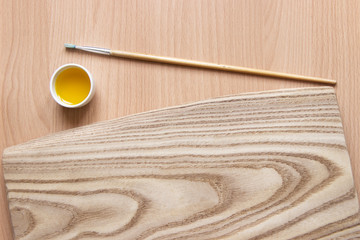 treatment of wood with impregnation for protection. linseed oil on the board with a brush. wooden board, tassel and oil with copy space for text. Water-repellent ecological safe for health.