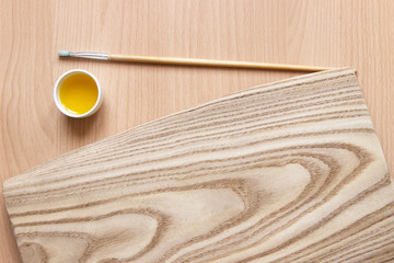 treatment of wood with impregnation for protection. linseed oil on the board with a brush. wooden board, tassel and oil with copy space for text. Water-repellent ecological safe for health.