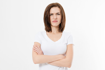 Upset and angry girl in white blank t shirt isolated on white background. Sad and mad woman with crossed arms . Copy space.