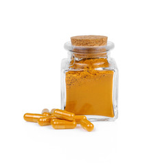 Turmeric powder and turmeric capsules on white background