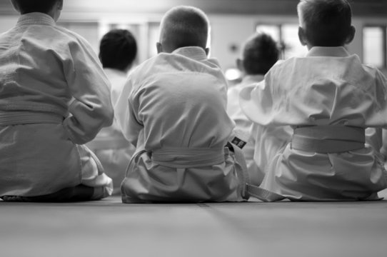 Kid's training on karate-do. With space for text. For web pages or advertising printing. Photo without faces, from the back.