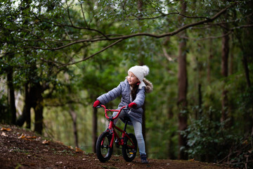 Fototapeta na wymiar 森の中で自転車に乗る女の子