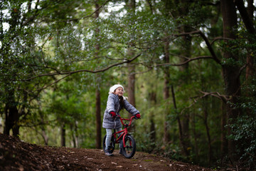 Fototapeta na wymiar 森の中で自転車に乗る女の子