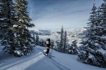 Skier enjoys the view towards the Rocky Mountains during winter - obrazy, fototapety, plakaty
