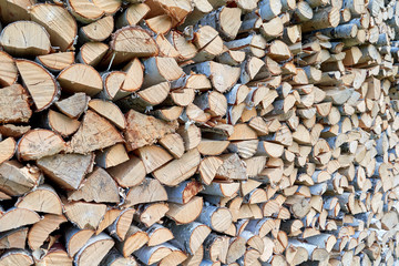 Large pile or stock of firewood for heating furnace. Logs and logs of birch. The log is split in half. Slice as a circle, semicircle. Background, backdrop, texture. Side view.