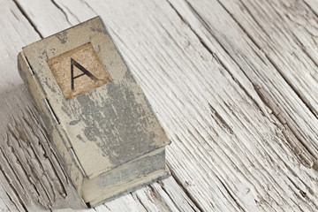 Nostalgic still life with little tin box with letter A