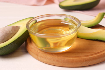 avocado oil and avocado fruit on a wooden table.
