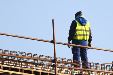 Builder at the reconstruction area ower blue sky