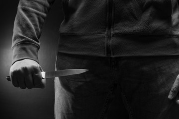 Man attacks with a knife. The threat of cold weapons. The concept of crime and robbery.