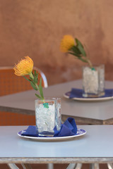 A yellow flower in a vase on the table