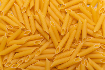dry yellow pasta on the table, top view as background
