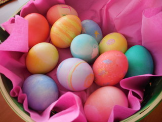 Colored Easter eggs in pink basket from above