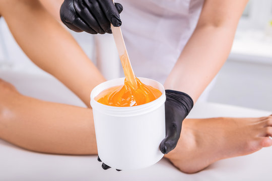 Professional sugaring master using gel for removing hair