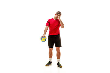 The sad fit caucasian young male handball player at studio on white background. Human emotions concept