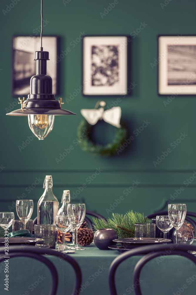 Wall mural black industrial lamp above dining table with wine glasses, plates and cones