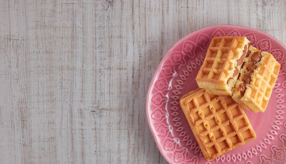 Top view sweet fresh Viennese waffles on plate isolated on wooden table. copy space. European for breakfast.