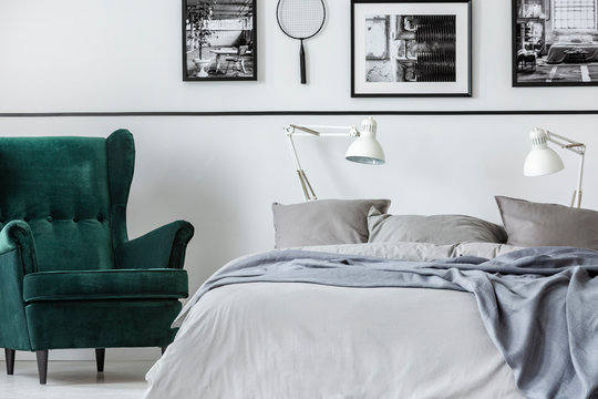 Photo collector bedroom with emerald armchair and king size bed with grey bedding