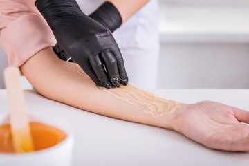 Close up of master in hair removal using depilatory wax