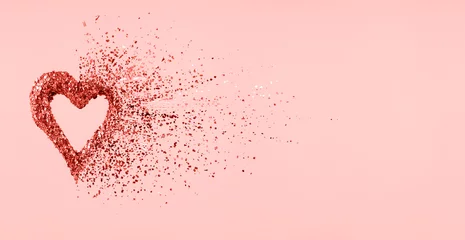 Glitzerherz, das sich auf rosafarbenem Hintergrund in Stücke auflöst. Valentinstag, gebrochenes Herz und Liebesentstehungskonzept. Living Coral Thema - Farbe des Jahres 2019 © Ekaterina_Molchanova