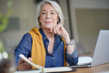  Fresh looking senior woman thinking and working from home