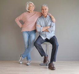  Full length of happy senior couple on grey background