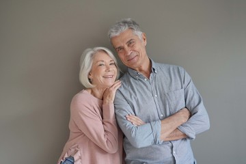  Lovely portrait of attractive senior couple on grey background