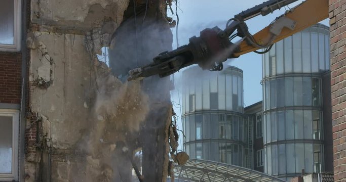 Demolition crane destroying old building slow-motion